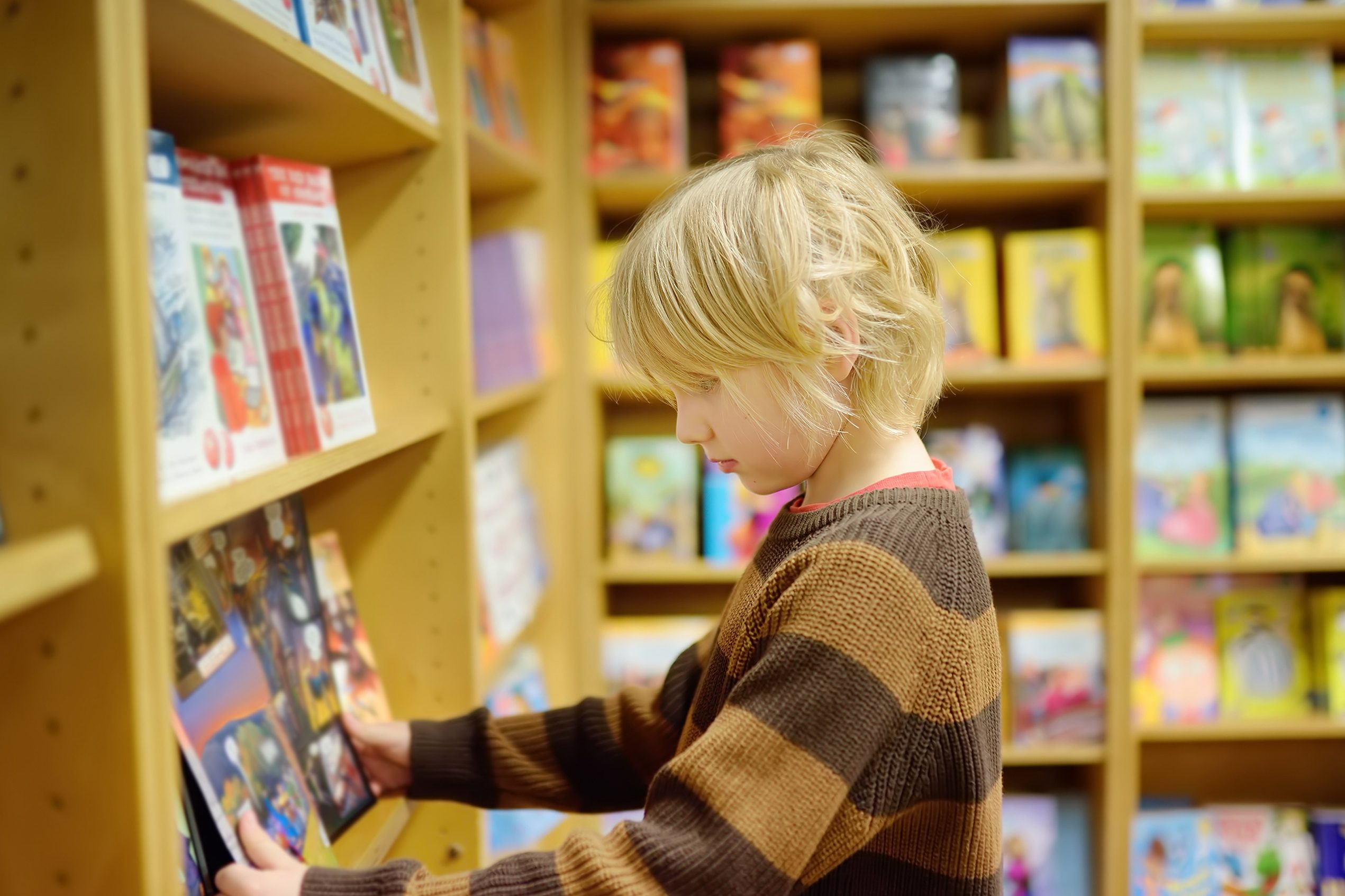 A,Preteen,Boy,Leafing,Through,A,Book,While,Standing,At